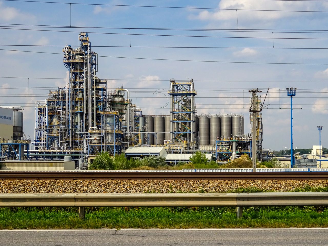 gallery-5 Image of a large chemical factory in Schwechat, Austria, showcasing industrial pipes and machinery.