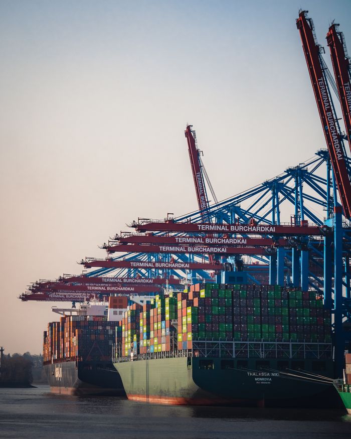 our-services-1 Cargo ships and cranes at Hamburg Burchardkai Terminal during day.