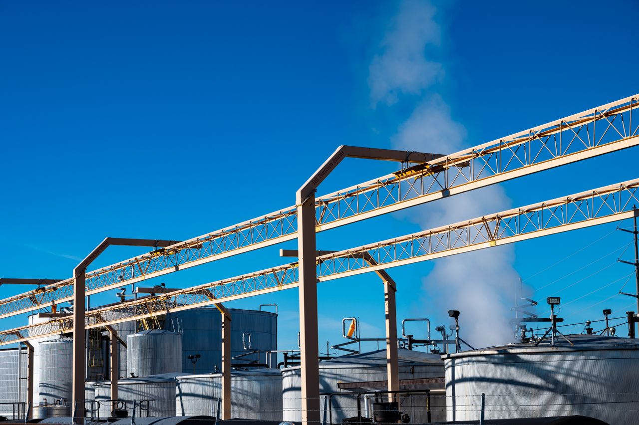 services-img Wide view of an industrial plant with smoke rising from storage tanks against a clear blue sky.