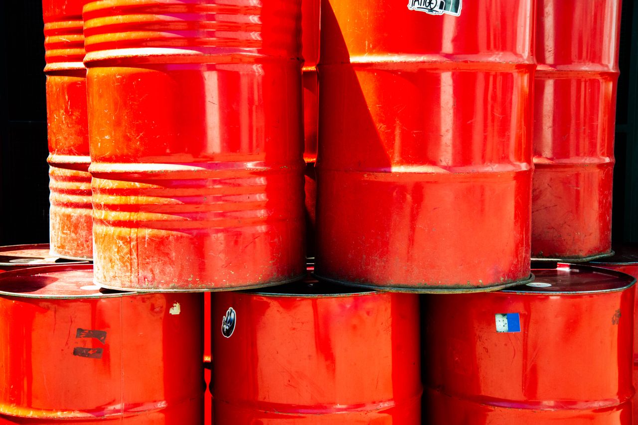 gallery-3 Bright red industrial oil barrels stacked outdoors in daylight, showcasing vivid color and industrial theme.