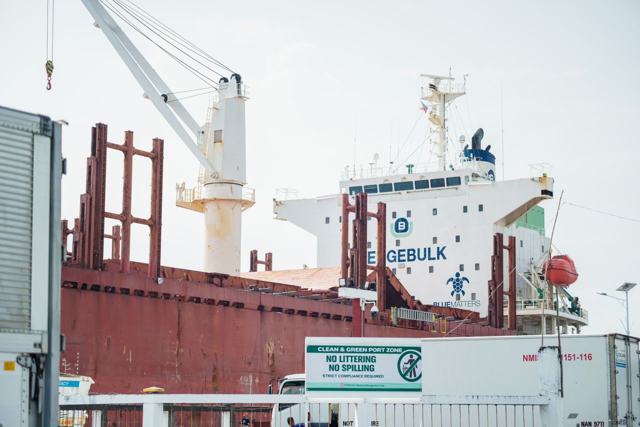 about-01 A cargo ship named Egebulk docked at a port, with cranes and containers visible.