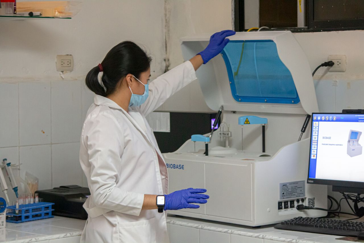about-img Woman scientist in lab coat working with laboratory equipment indoors.