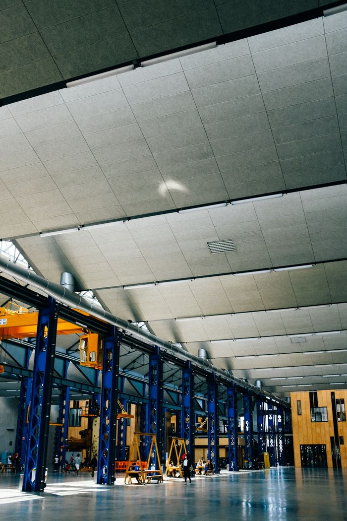 services-01 Spacious indoor warehouse with steel beams and machinery, ideal for industrial applications.
